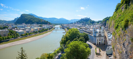 view to Salzburg old town beside steep rock face, Salzach river and the fortress behind
