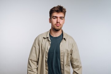 Fototapeta premium Young man with casual attire against a plain background.