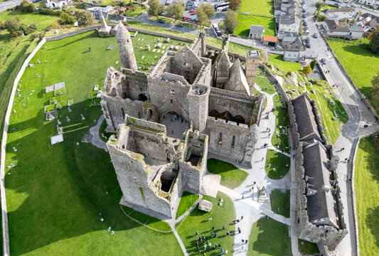 Aerial view of the Rock of Cashel, a majestic medieval site, stands proudly amidst verdant fields, a testament to history and enduring stone, Cashel, County Tipperary, Ireland.