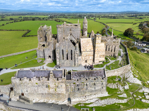 Aerial view of Rock of Cashel, a medieval architectural complex of stone buildings standing majestically against the vibrant green fields, Cashel, County Tipperary, Ireland.