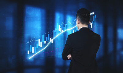 A business professional stands confidently, analyzing upward financial graphs on a digital screen in a sleek office setting. This image captures modern business dynamics. Impute