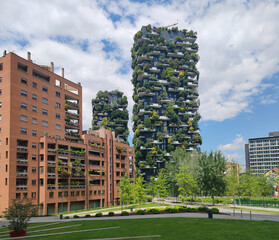 Milan, Italy – May 23, 2025: Modern residential towers of the Bosco Verticale complex rise above a landscaped urban park in the Porta Nuova district © Andrei Antipov