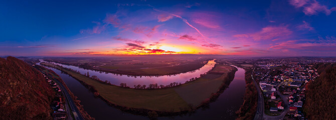 Sonnenuntergang &uuml;ber dem Fluss mit Blick auf die Landschaft und die Stadt