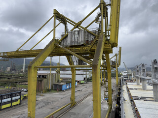 port quay with extremely large heavy-duty port cranes designed for handling metal cargo. Industrial harbor landscape with powerful lifting equipment, port infrastructure and maritime logistics