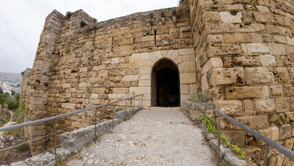 Ancient stone fortress entrance with arched doorway and pathway.