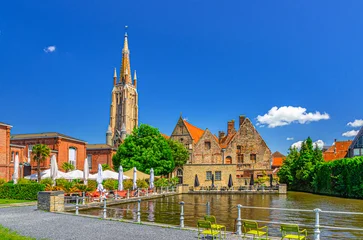 Fotobehang Brugge Bruges cityscape, Bakkersrei water canal of Reie river, Church of Our Lady, Old St John’s Hospital building in Brugge old town, Saint John embankment in Bruges city centre, West Flanders, Belgium  © Aliaksandr