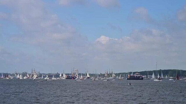 Segelboote und Yachten auf ruhigem Wasser mit bewaldeter K&uuml;stenlinie und bew&ouml;lktem Himmel, Windjammer Parade Kiel 2025, Heikendorf, Kreis Pl&ouml;n, Kieler F&ouml;rde, Schleswig-Holstein, Deutschland, Europa 