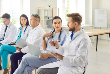 A group of worried doctors sits in a clinic auditorium, close-up. Training to improve the...
