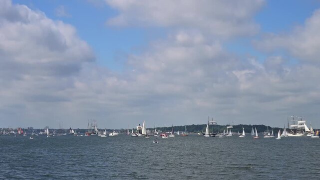 Segelboote und Yachten auf ruhigem Wasser mit bewaldeter K&uuml;stenlinie und bew&ouml;lktem Himmel, Windjammer Parade Kiel 2025, Heikendorf, Kreis Pl&ouml;n, Kieler F&ouml;rde, Schleswig-Holstein, Deutschland, Europa 
