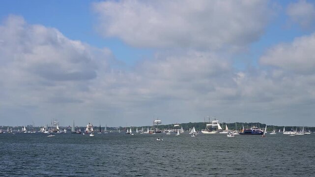 Segelboote und Yachten auf ruhigem Wasser mit bewaldeter K&uuml;stenlinie und bew&ouml;lktem Himmel, Windjammer Parade Kiel 2025, Heikendorf, Kreis Pl&ouml;n, Kieler F&ouml;rde, Schleswig-Holstein, Deutschland, Europa 