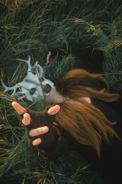 mujer con mascara de ciervo tirada en el suelo