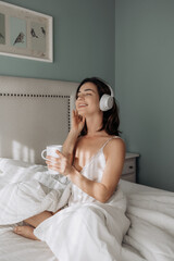 Woman, headphones and happy on bed, relax and eyes closed with streaming subscription in home. Girl, person and smile with audio tech, sound and listening to music