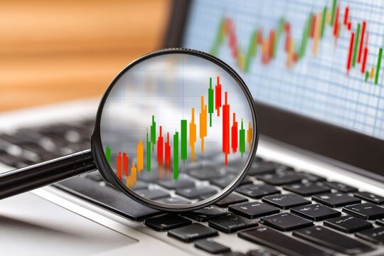 Magnifying candlestick chart data on laptop for financial analysis - Powered by Adobe