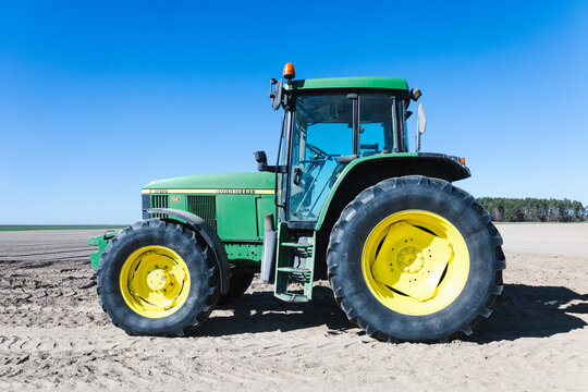 Jastrzebniki, Poland - April 3, 2025. Side view of a John Deere 6610 tractor standing in the field on a sunny day in spring.