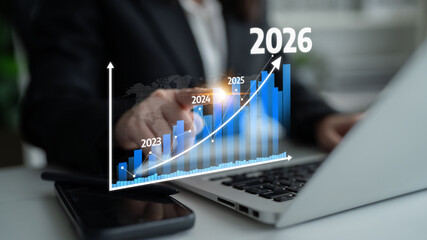 A business professional examines a digital growth chart on a laptop, focusing on future projections from 2023 to 2026, showcasing financial trends and data insights. Tessel