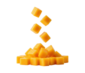 Ripe mango cubes falling onto a pile of fresh mango pieces, showcasing vibrant tropical fruit on a clean background