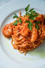 A plate of spaghetti with shrimps and tomatoes