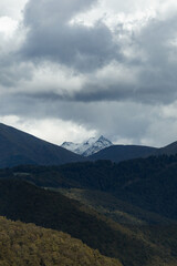 Fototapeta premium Rugged Mountain With Icy Summit Piercing Through Ominous Storm Clouds And Bleak Ridgelines
