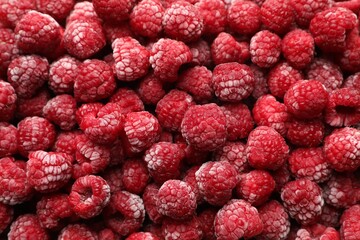 Frozen ripe raspberries as background, top view