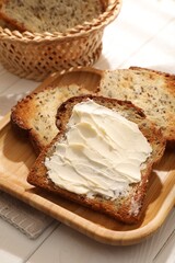 Bread slices with butter on white wooden table, closeup
