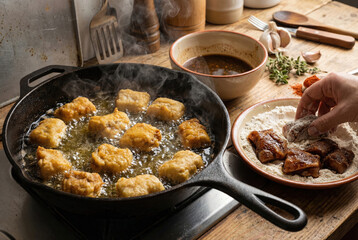 Proceso de rebozado y fritura del caz&oacute;n en adobo en sart&eacute;n de hierro fundido.