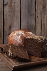 Different types of bread on wooden table, closeup