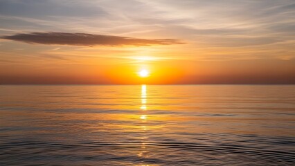 Obraz premium Golden sunset over calm ocean water with vibrant orange and yellow sky