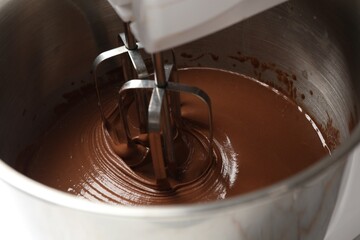 Mixing chocolate dough in bowl, closeup view