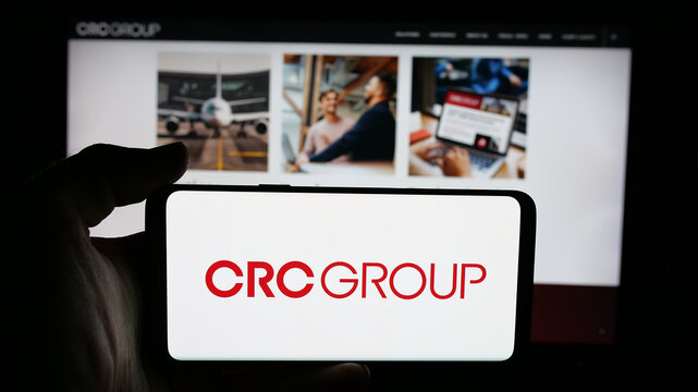 Stuttgart, Germany - 11-28-2025: Person holding cellphone with logo of US company CRC Insurance Services LLC on screen in front of webpage. Focus on phone display.