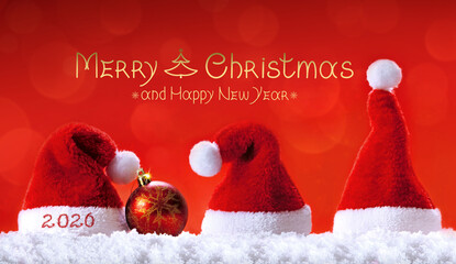 Merry Christmas and Happy New Year 2026 and red Santa hats on white snow.