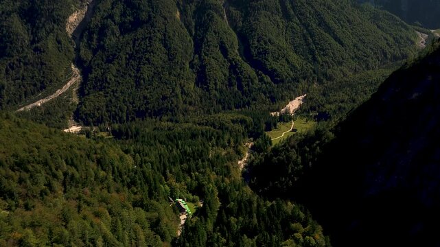Expansive view of rugged Slovenian mountains south of Kranjska Gora, featuring dense green forests, rocky peaks, and deep alpine valleys under clear skies. 4k stock video