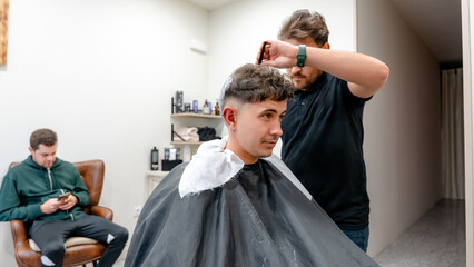 Hairdresser applying hair bleach at a modern barbershop