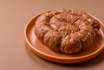 Fototapeta premium Grilled sausage in the shape of a spiral or snail, from chicken or pork. Spiral or snail sausage