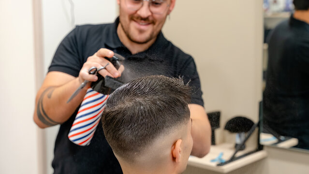 Barber applying finishing touches on a stylish haircut