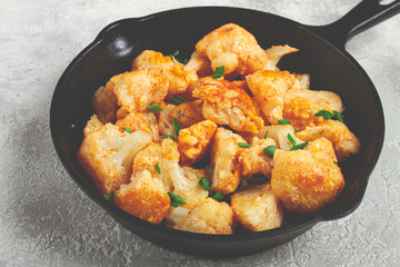 Fried cauliflower, with spices and herbs, in a cast-iron pan, homemade, no people,