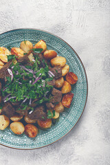 kuyrdak, roast offal with potatoes and fresh herbs, homemade in Kazakh, no people,