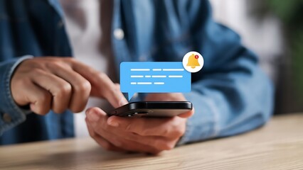 Person using smartphone with notification bubble and bell icon, close-up