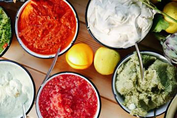 Overhead Flat Lay of a Vibrant Mediterranean Buffet Spread Featuring Hummus, Salsas, Olives, Dips, and Fresh Citrus Fruits