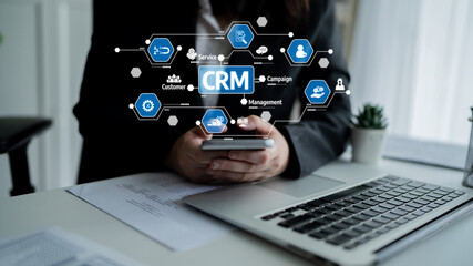 A business professional interacts with a smartphone in a modern office, with a visual overlay of CRM concepts, emphasizing technology in customer relationships. Tessel