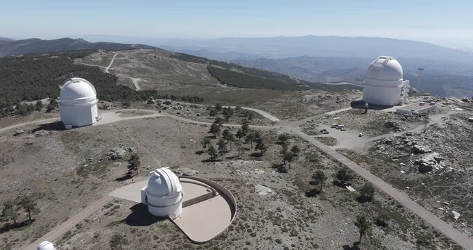 Aerial drone shot of Calar Alto Observatory telescopes in the Sierra de Los Filabres mountain range in Sierra Nevada, Almeria, Andalusia, Spain. Largest observatory in Europe. Sunny, clear blue sky 