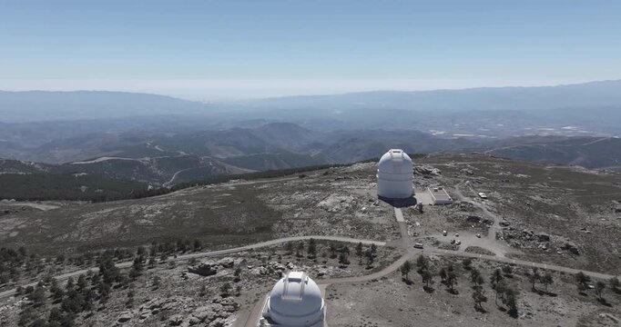 Beautiful aerial drone shot of Calar Alto Observatory telescopes in the Sierra de Los Filabres mountain range in Almeria, Andalusia, Spain. Largest observatory in Europe. Sunny, clear blue sky 