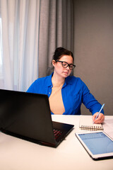 Young entrepreneur developing startup business plan at home. Determined woman working on financial projections. Innovation, business planning, and business startup concept