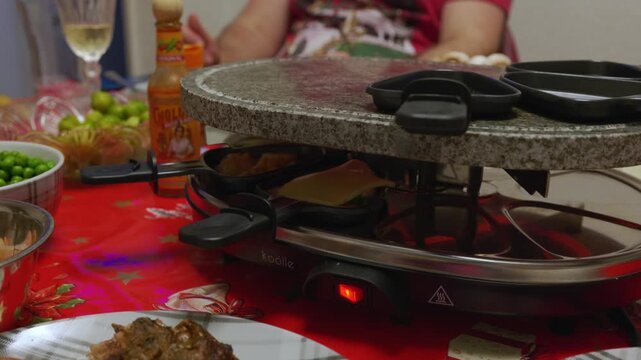 Tabletop grill with grilling plates filled with food being cooked and shared