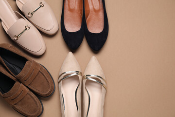 Different stylish shoes on beige background, flat lay. Space for text