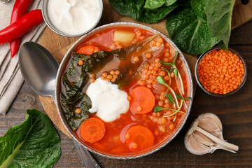 Tasty lentil soup served on wooden table, flat lay