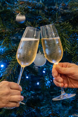 A celebratory toast in front of a Christmas tree