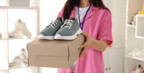 Sales associate showing shoes in store, closeup