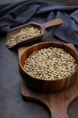 Pile lentil in wooden spoon isolated on Woden background. Top view.