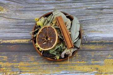 Winter tea for health in cold weather. Flavored with ginger, cinnamon, hibiscus, and orange. Isolated on woodenn background