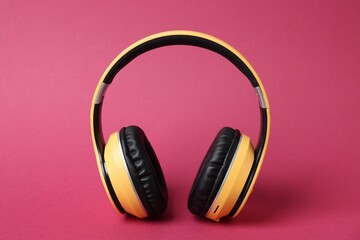 Pair of stylish headphones on pink background, closeup